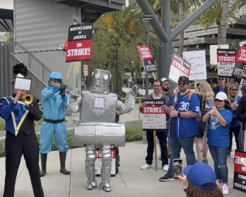Dispatches From The Picket Lines, Day 24: Sen. Gillibrand & Colin Farrell Speak In NY; Lil Wayne Sends Burgers, A Robot Pickets & A Marching Band Plays In LA